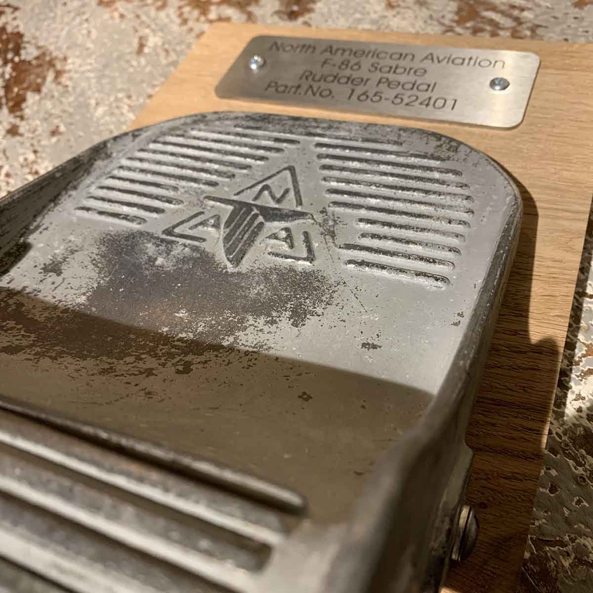 Detail of a North American F-86 Sabre rudder pedal on a wooden base.