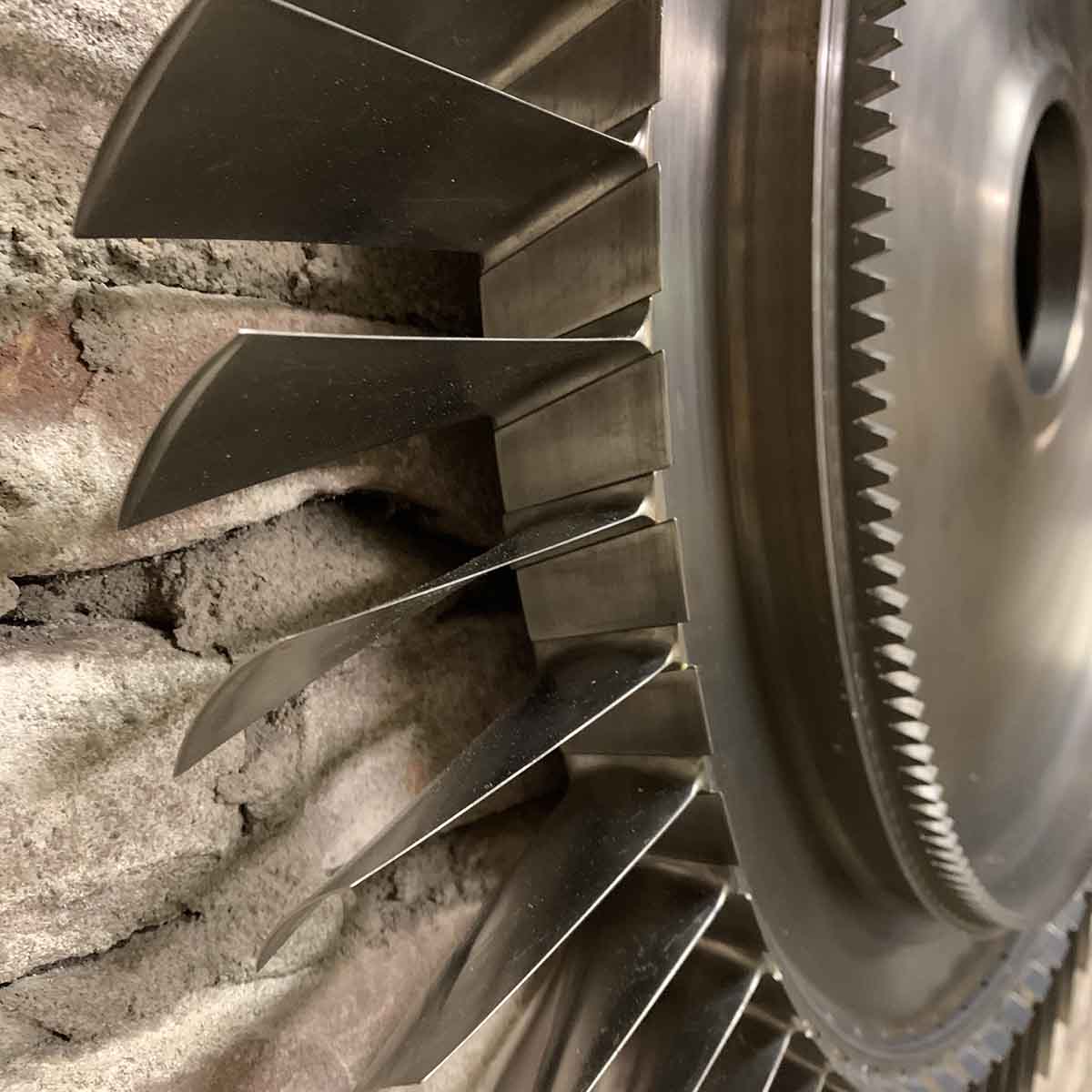 Detail of a Lyulka AL-21F3 engine compressor stage rotor against a brick wall.