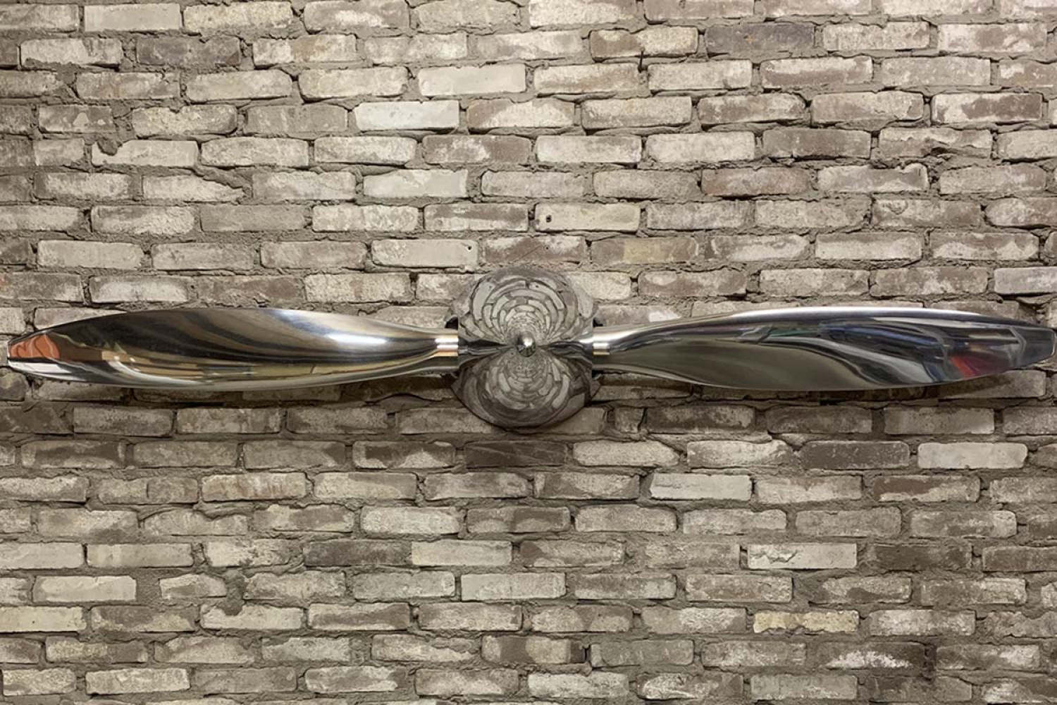 Background photo of propeller blade on mirror polished Hartzell propeller and spinner for sale.