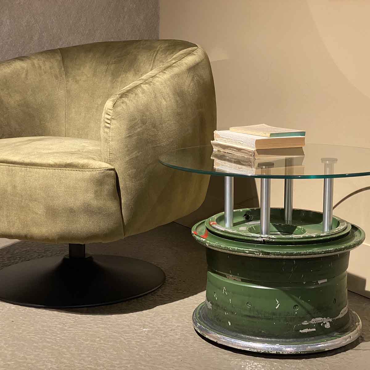 Side table made of main landing wheel of a MiG-29 Fulcrum next to a lounge chair.