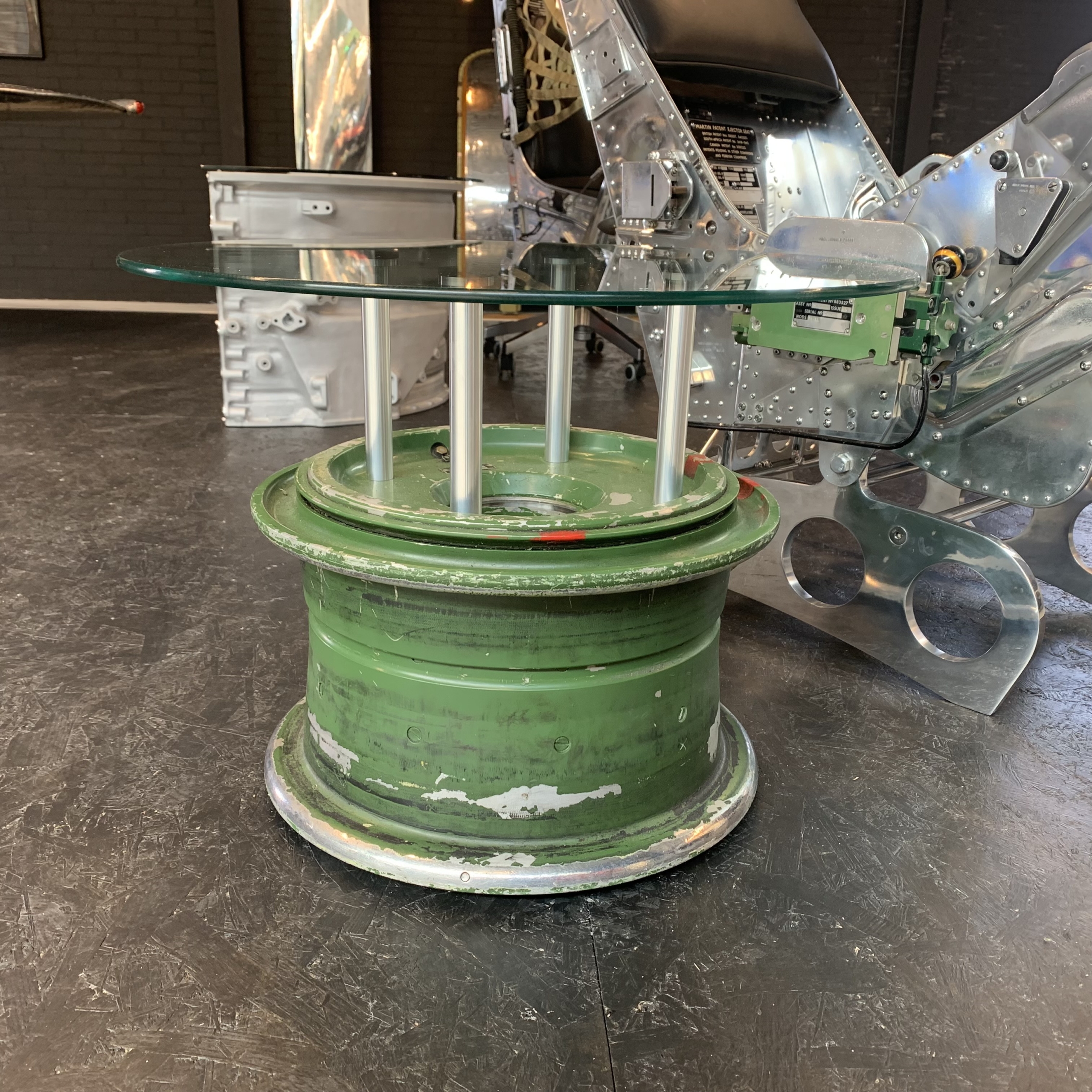 Side table made of main landing wheel of a MiG-29 Fulcrum next to a Martin-Baker ejection seat..