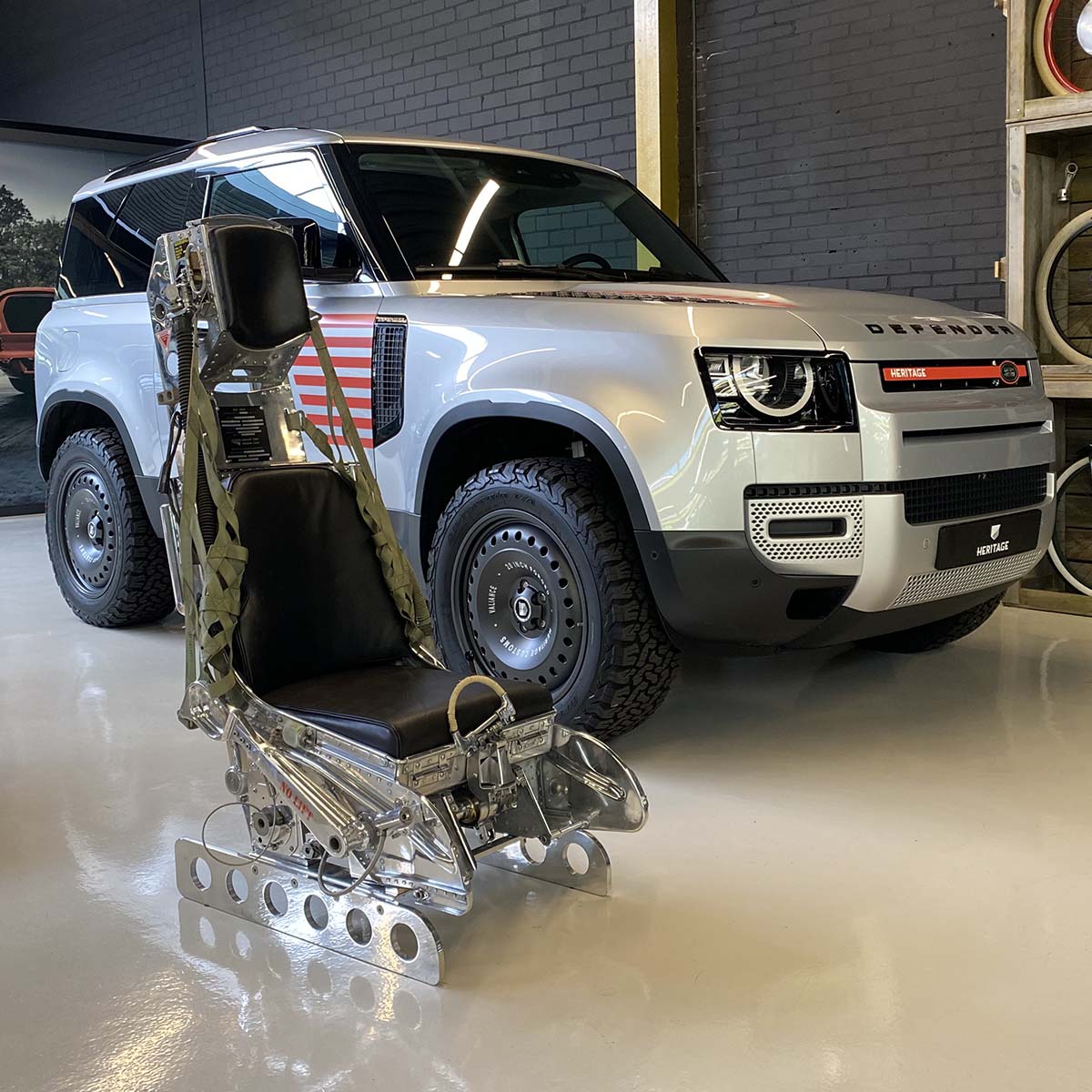 Mirror polished Lockheed C2 ejection seat from a Starfighter in front of a customized Land Rover Defender.