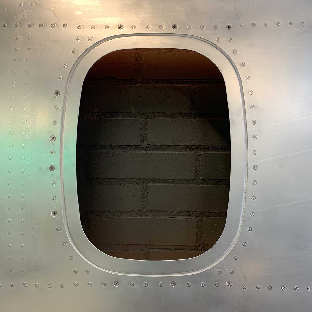 Detail showing one window of a six-window panel of an ATR passenger aircraft turned into a decorative piece.