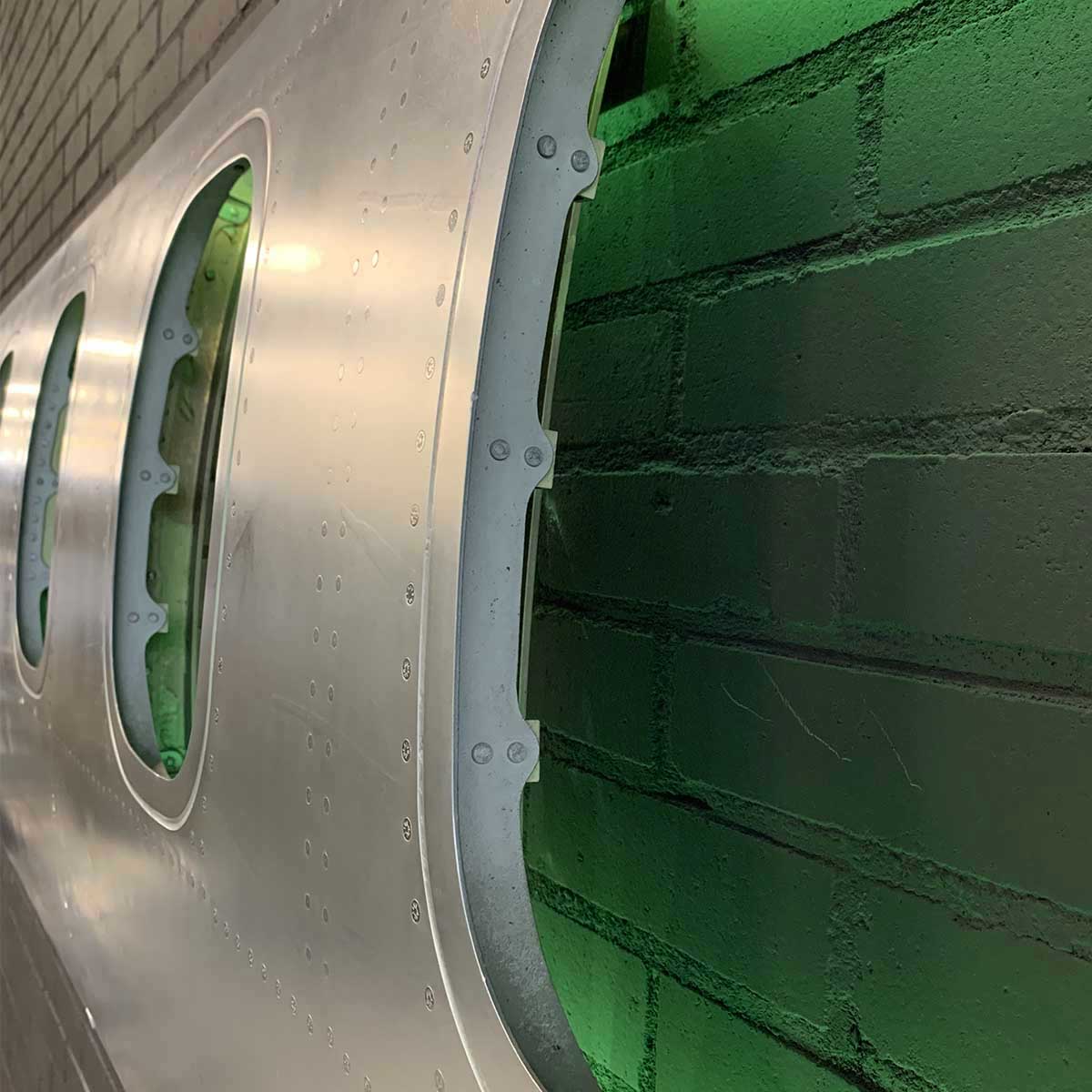 Detail showing green colours on a six-window panel of an ATR passenger aircraft turned into a decorative piece.