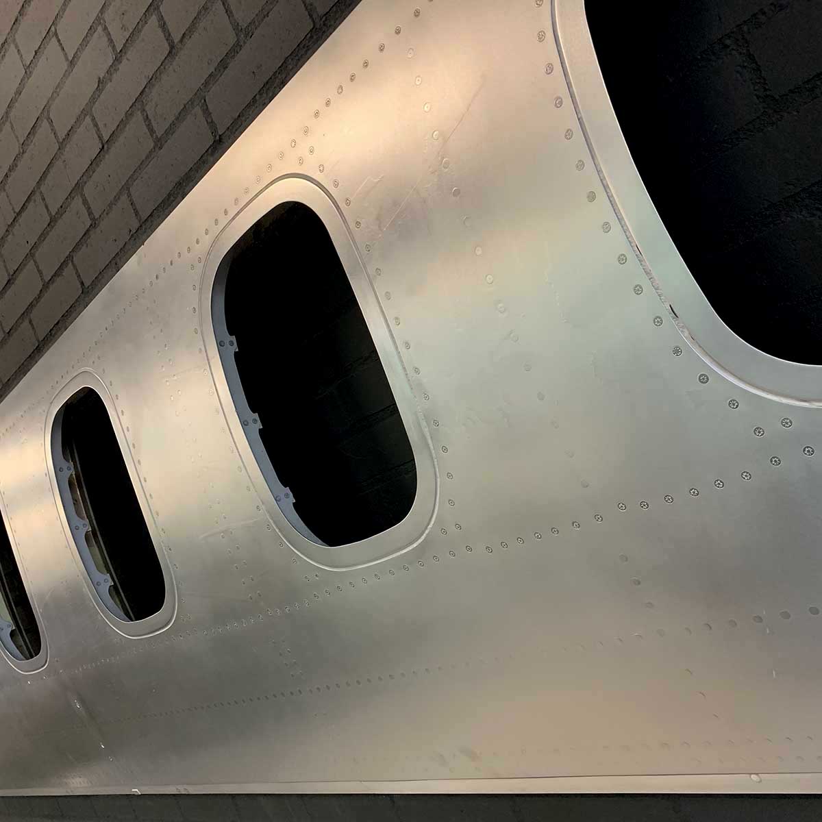 Detail showing the matte finish of a six-window panel of an ATR passenger aircraft turned into a decorative piece.