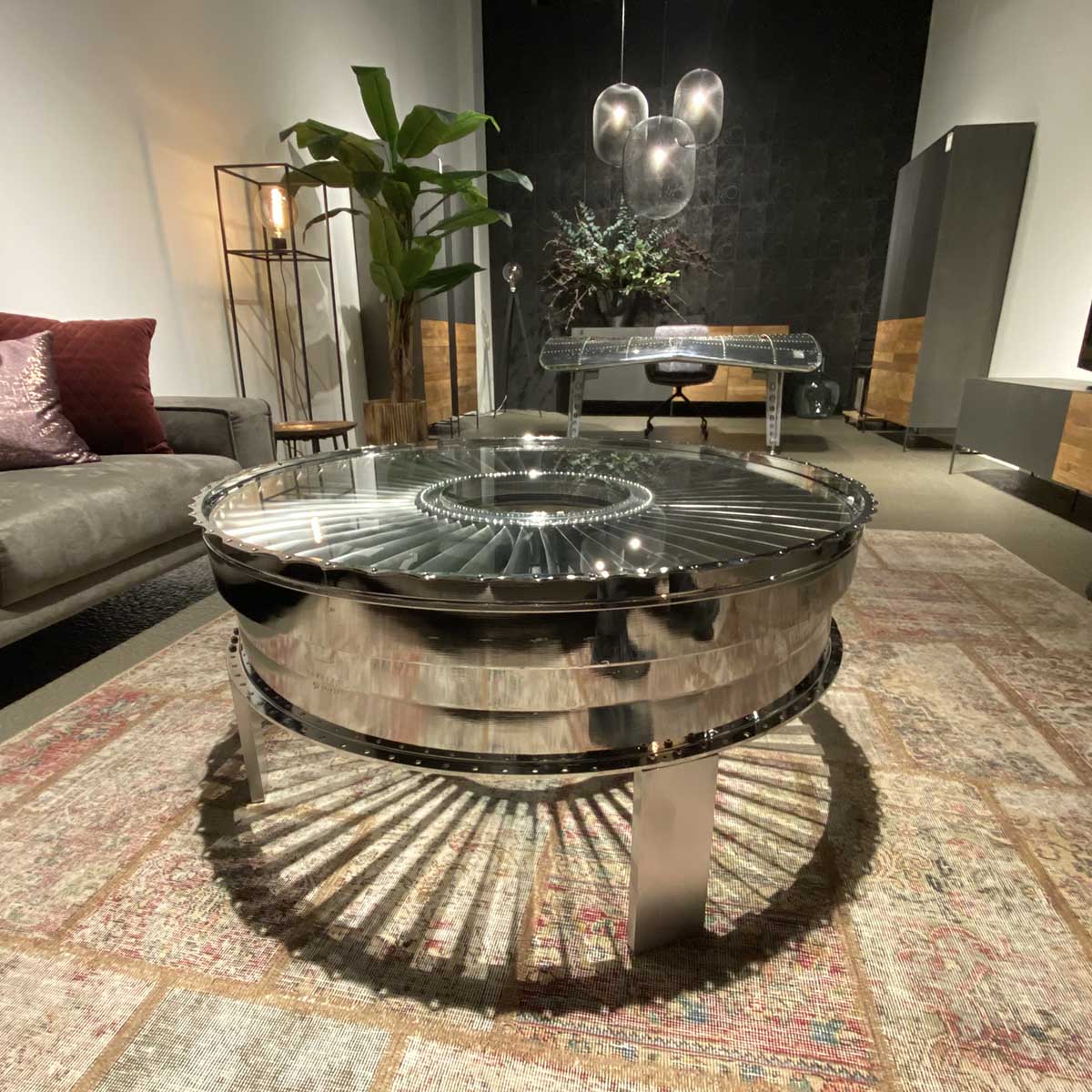 Polished rear fan case of a P&W JT8D in use as a table in a modern living room.