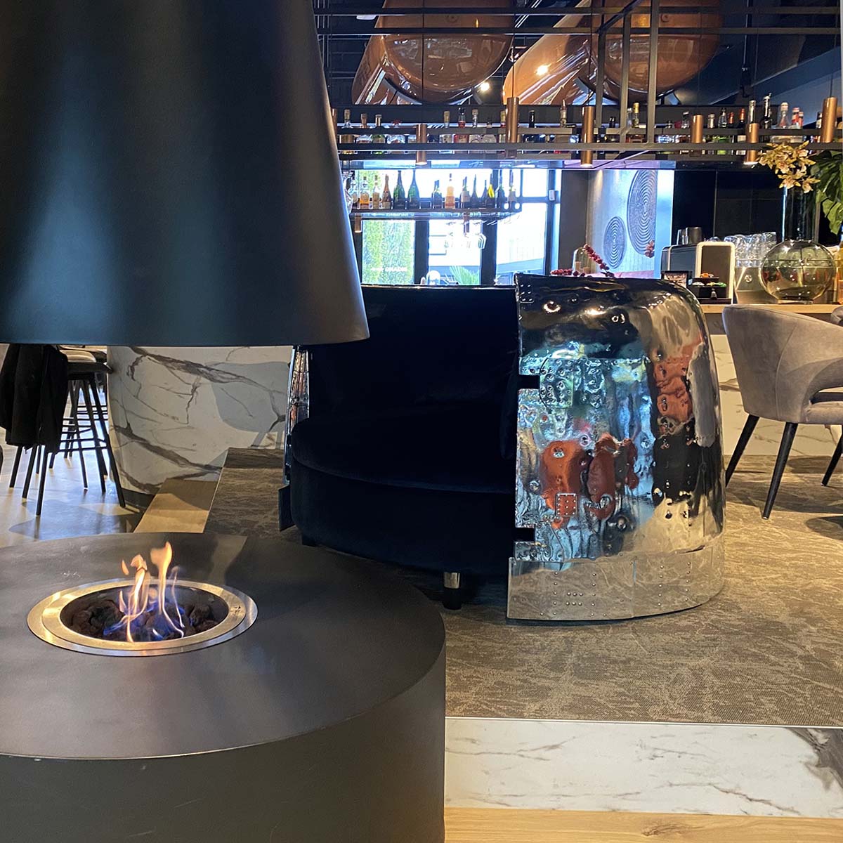 DC-3 Dakota engine cowling love seat next to a fire place in a restaurant.
