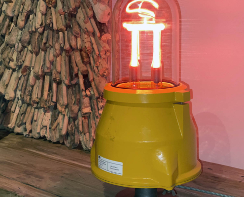 Refurbished AEG Berlin neon airport obstruction light in use as a light in an interior.