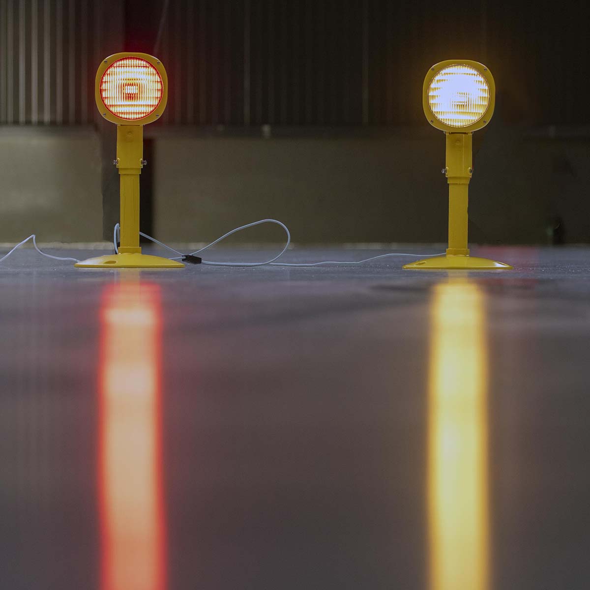 Two refurbished Thorn runway approach lights, one with a white lens, one with a red lens.