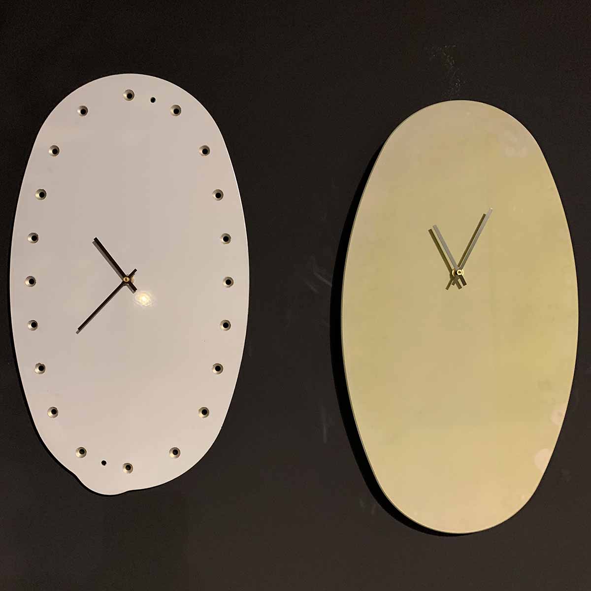 Two British Airways Airbus A318 fuel panel clocks hanging on a black wall.