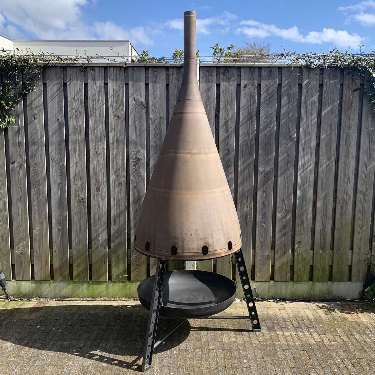 Large outdoor fireplace that was made using the exhaust cone of a Boeing 747 engine.