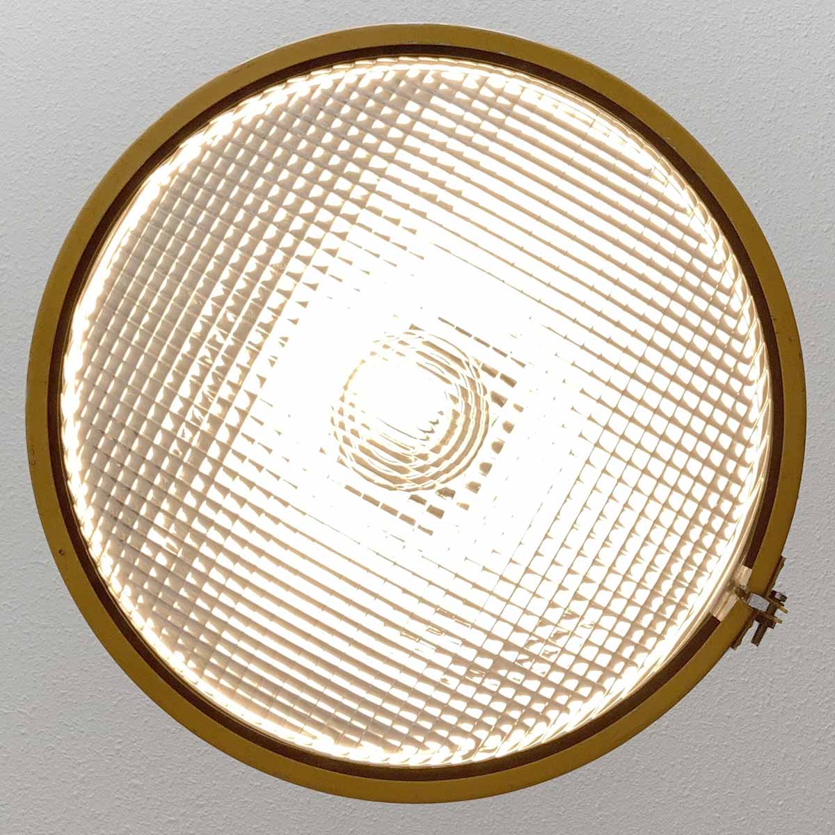View of the glass of a large Philips runway light, now in use as a ceiling light.